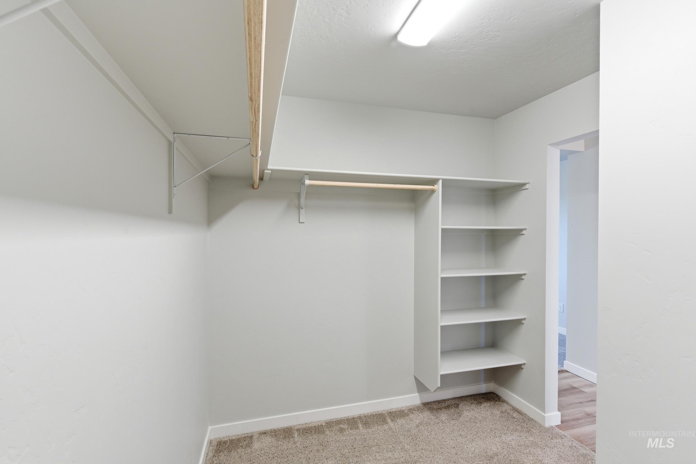 13709 Redway Court Caldwell, ID 83607 - Photo 26 of 28 Walk-in closet featuring built-in shelving, hanging rods, recessed ceiling lighting, and neutral-tone carpet