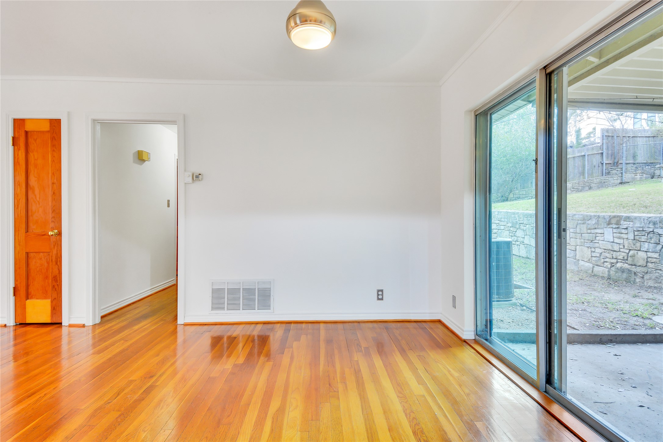 2300 Rebel Road Austin, TX 78704 - Photo 9 of 26 Hardwood floors meet outdoor views through the sliding glass doors, creating an inviting atmosphere.
