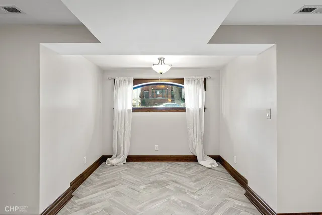 an empty room with mirror and windows