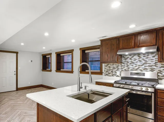 a kitchen with stainless steel appliances granite countertop a sink stove and refrigerator