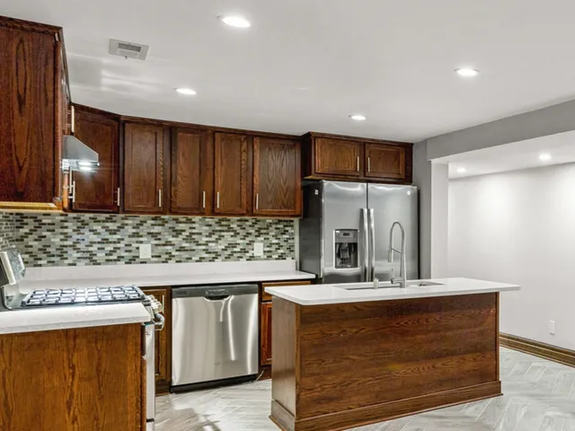a kitchen with stainless steel appliances granite countertop wooden cabinets and a counter top space
