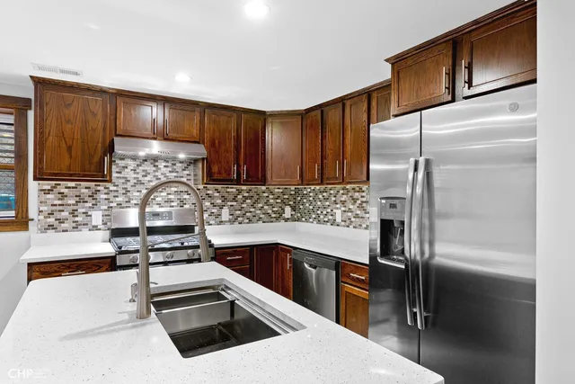 a kitchen with granite countertop a refrigerator sink and stove
