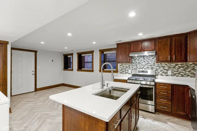 a kitchen with a sink a stove and cabinets