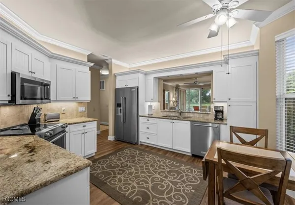 a kitchen with a refrigerator a stove a sink dishwasher with a dining table and chairs