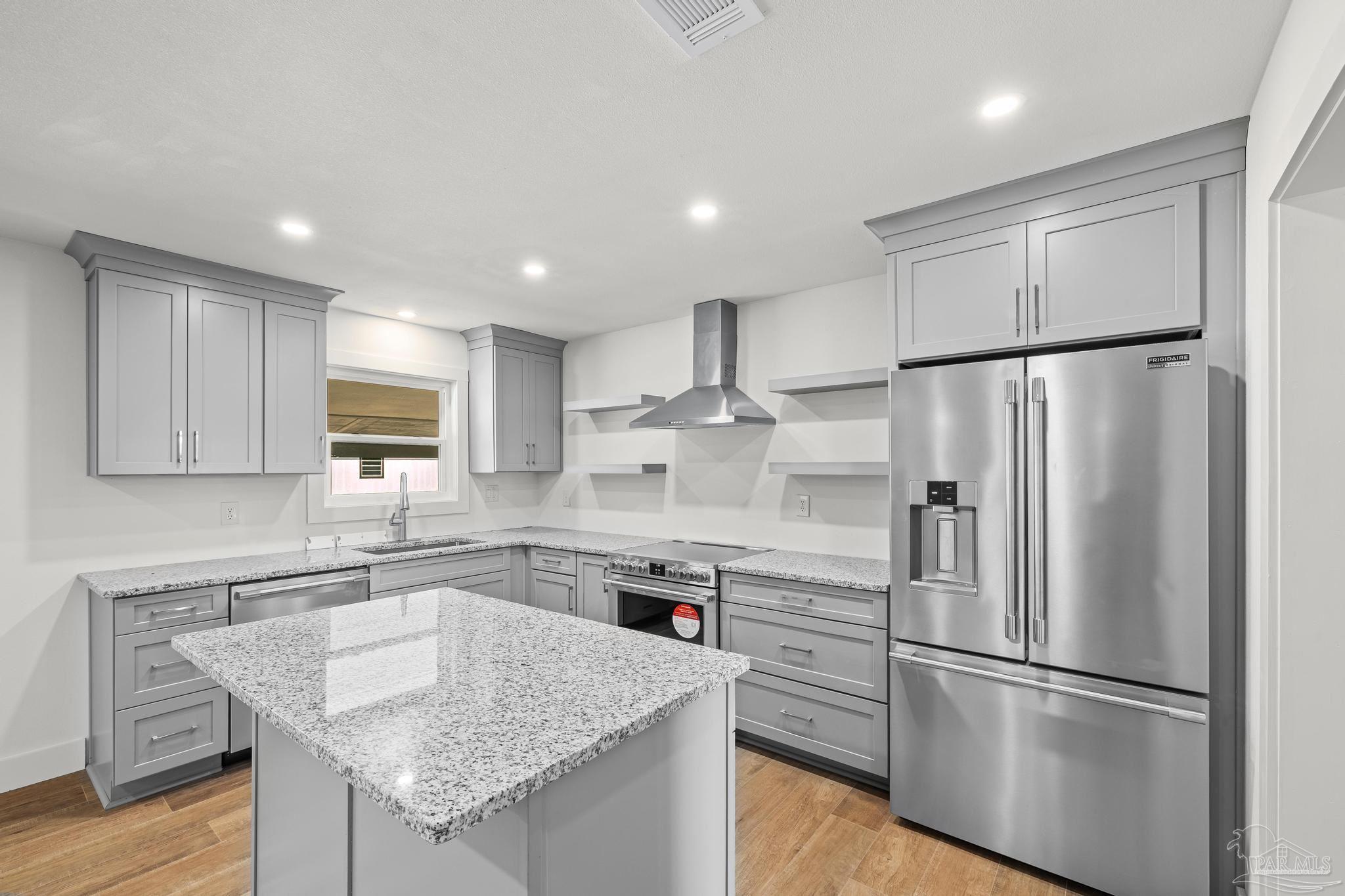 7988 Malone Road Milton, FL 32570 - Photo 12 of 69 a kitchen with kitchen island white cabinets and stainless steel appliances