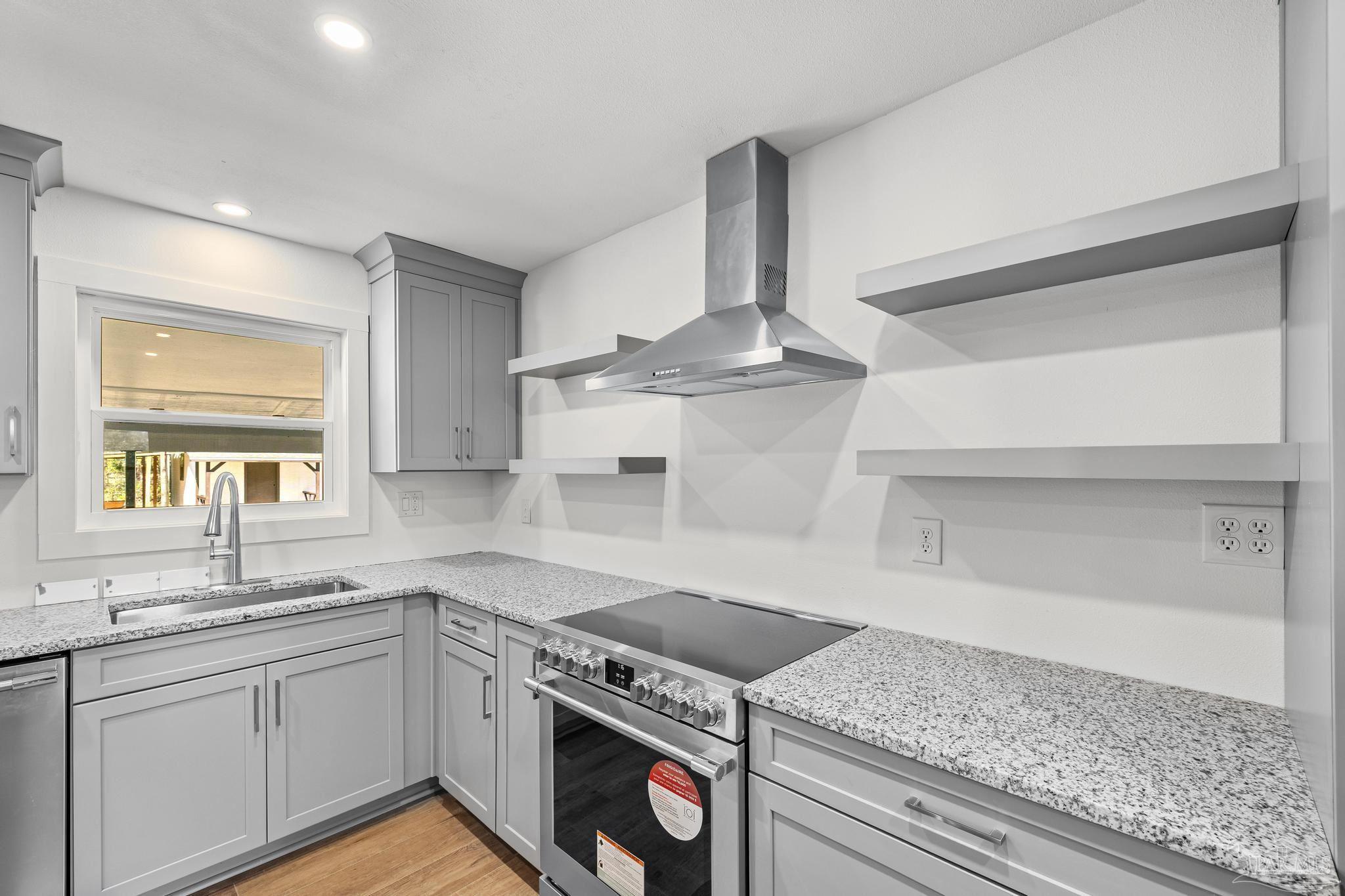 7988 Malone Road Milton, FL 32570 - Photo 17 of 69 a kitchen with granite countertop a sink stainless steel appliances and cabinets