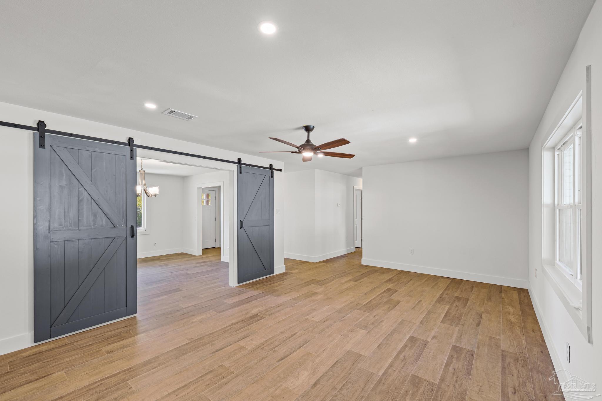 7988 Malone Road Milton, FL 32570 - Photo 19 of 69 an empty room with wooden floor fan and windows