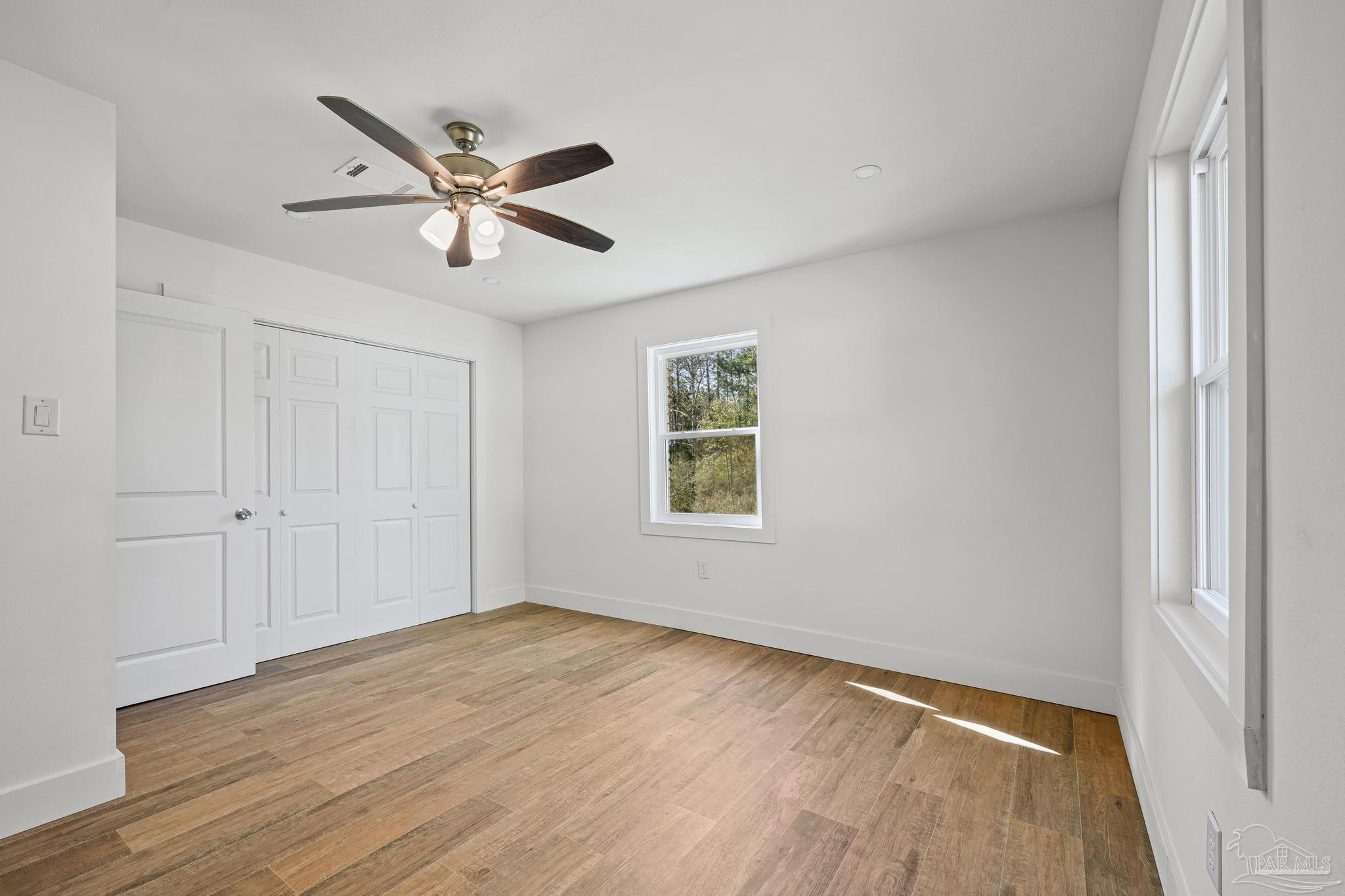 7988 Malone Road Milton, FL 32570 - Photo 27 of 69 a view of empty room with wooden floor and ceiling fan