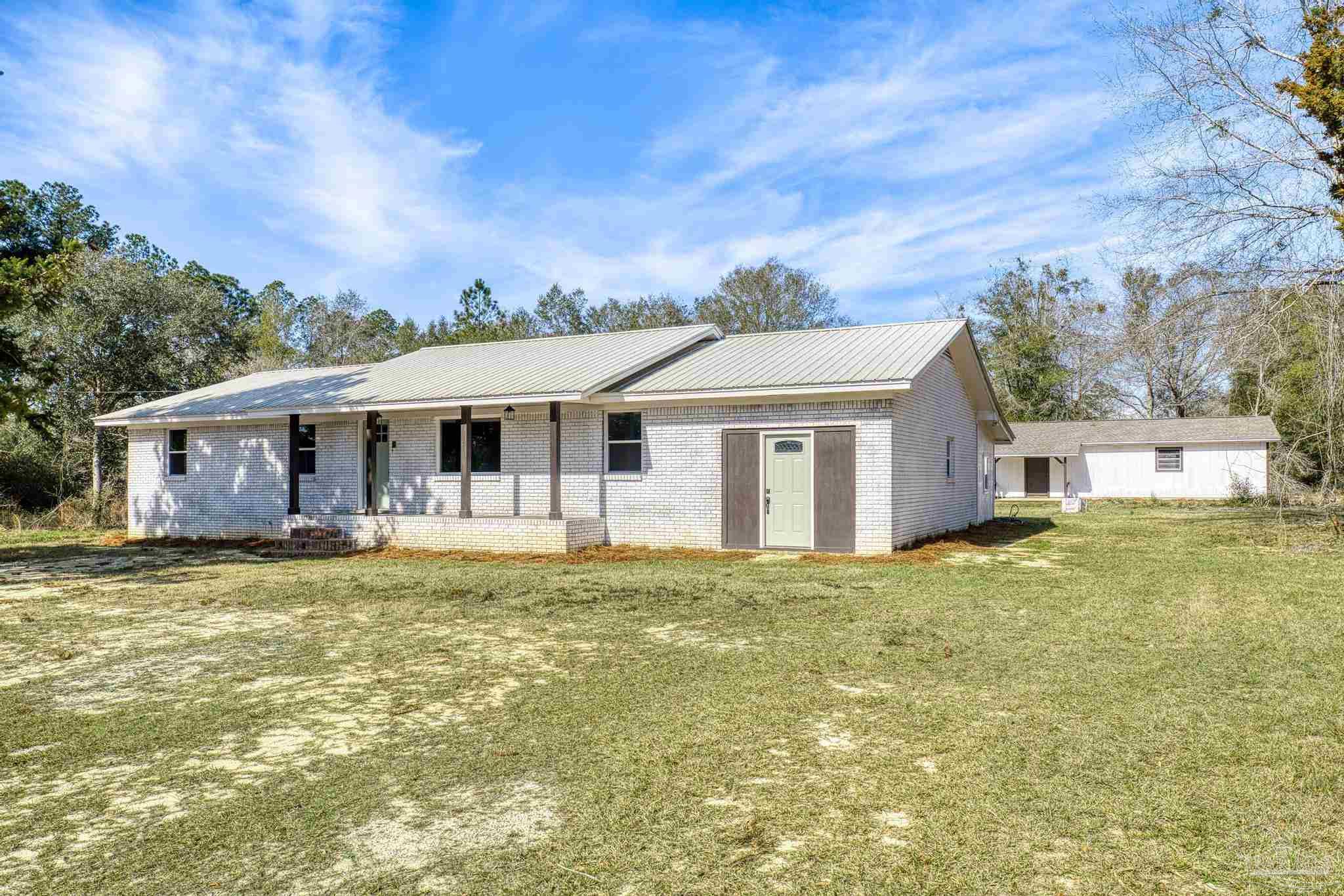 7988 Malone Road Milton, FL 32570 - Photo 3 of 69 a front view of a house with a garden