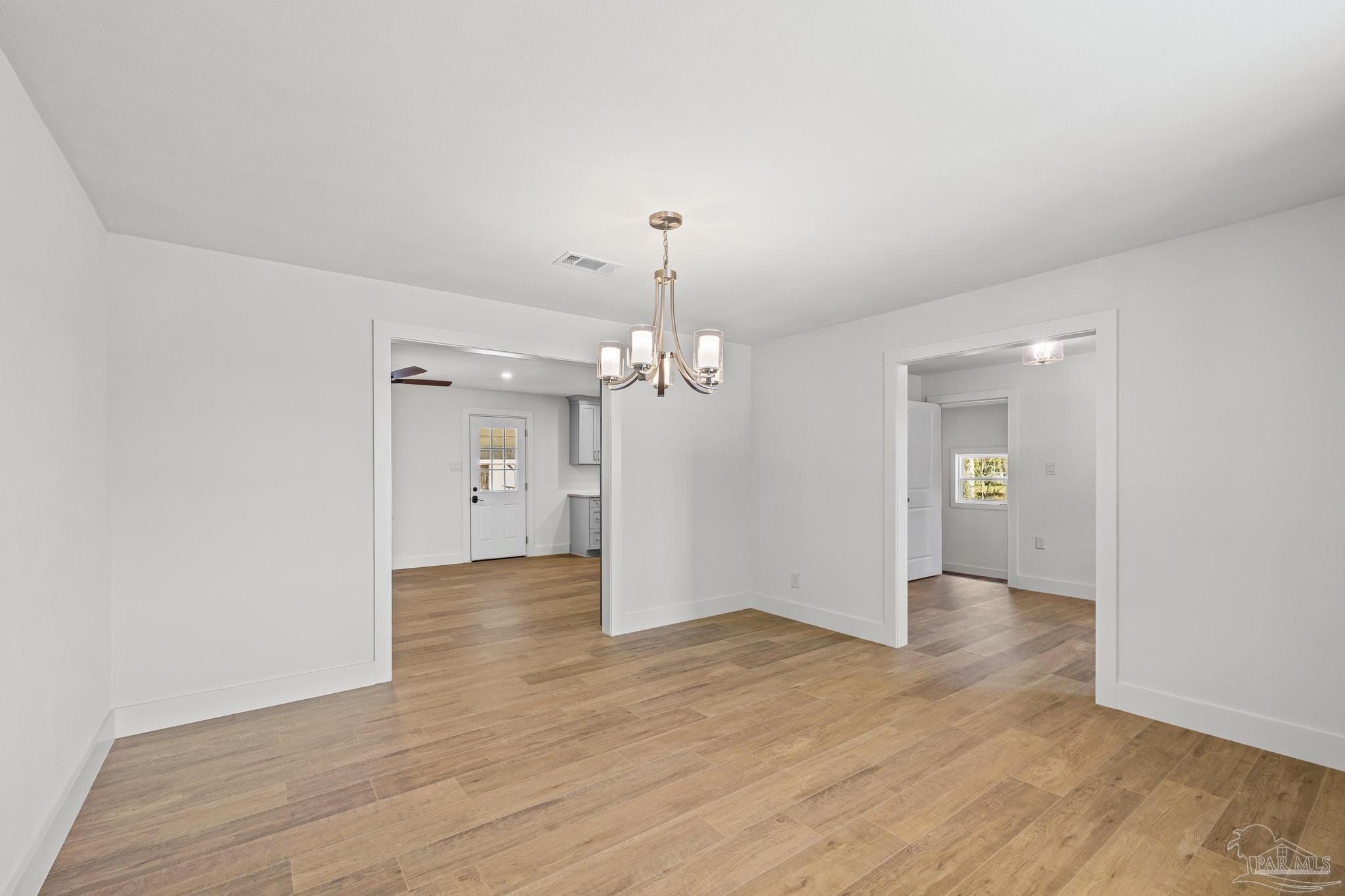7988 Malone Road Milton, FL 32570 - Photo 8 of 69 an empty room with wooden floor and windows