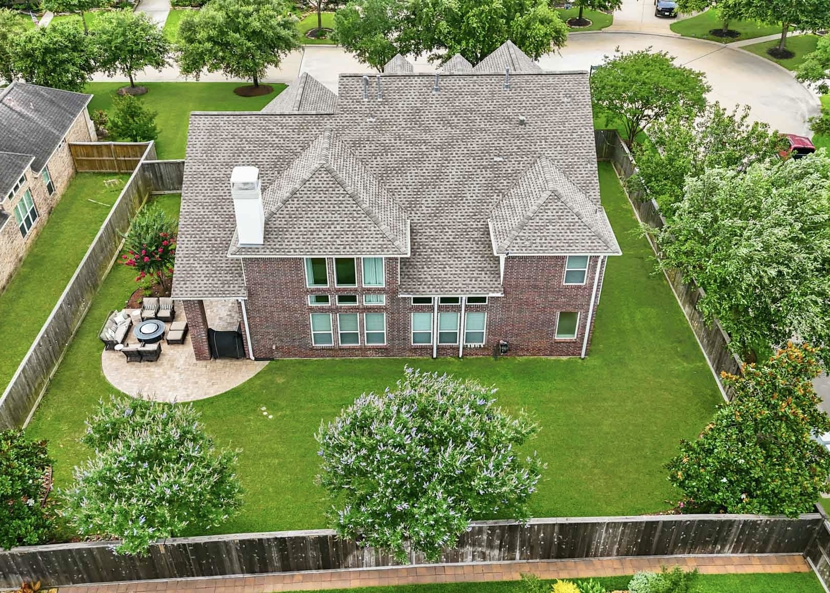 17610 Strackfield Lane Tomball, TX 77377 - Photo 45 of 50 A bird’s-eye view reveals one of the home’s most impressive features: a resort-inspired backyard with lush green space, mature landscaping, and a spacious paver patio ideal for dining, relaxing, and enjoying the outdoors year-round.