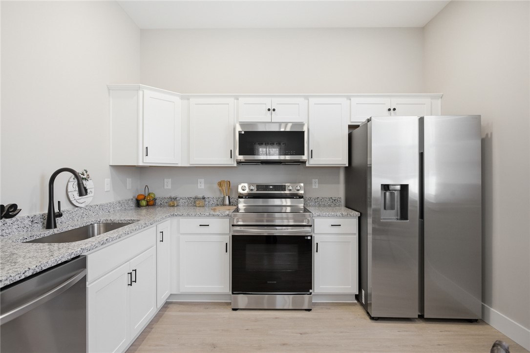 216 South Stribling Street Seneca, SC 29678 - Photo 11 of 38 This modern kitchen features bright white cabinetry, sleek stainless steel appliances, and elegant granite countertops.