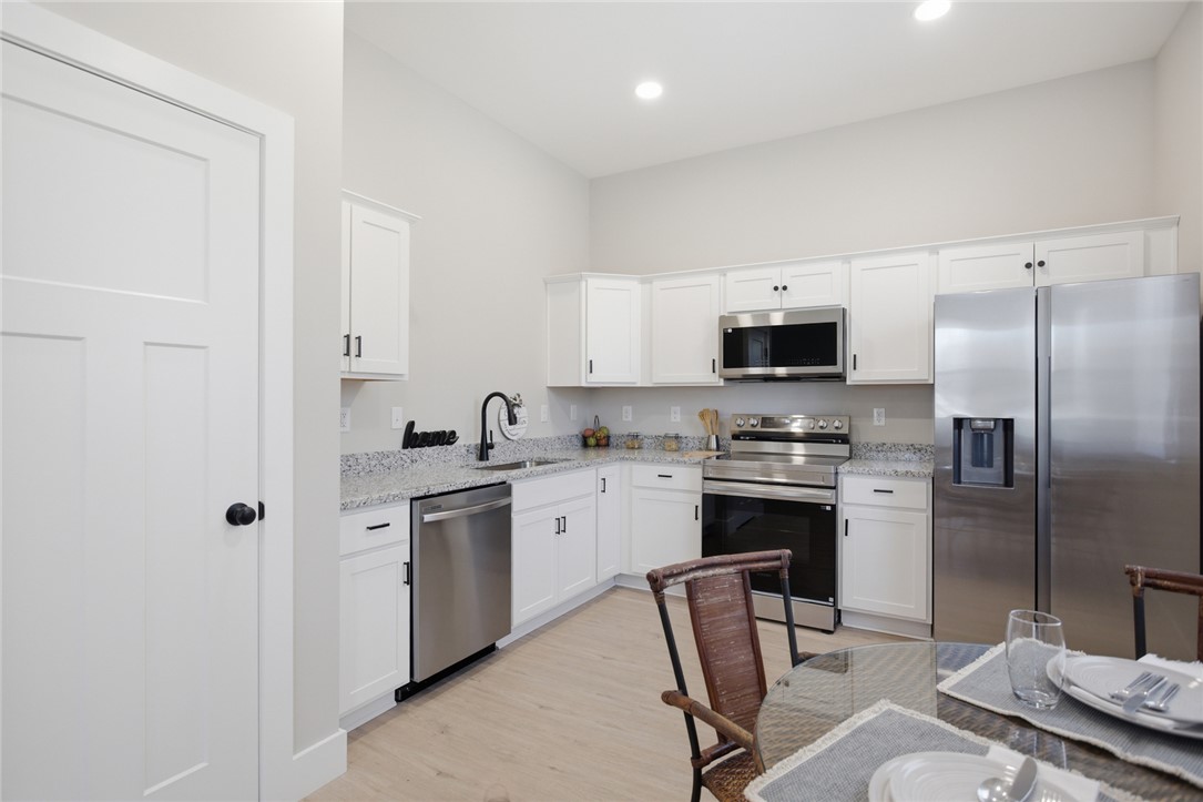 216 South Stribling Street Seneca, SC 29678 - Photo 10 of 38 This modern kitchen features bright white cabinetry and sleek stainless steel appliances, perfect for culinary endeavors.