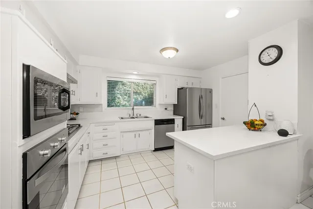 a kitchen with stainless steel appliances a refrigerator sink and stove