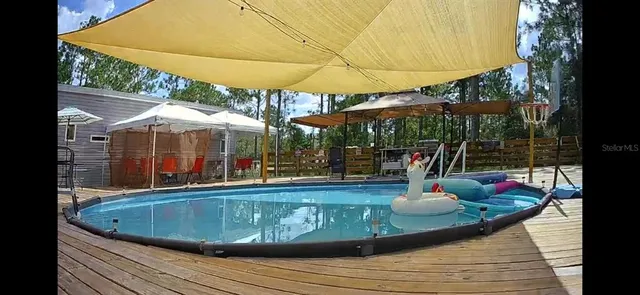 a view of a patio with a table and chairs under an umbrella