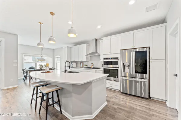 a kitchen with stainless steel appliances a stove center island refrigerator and cabinets