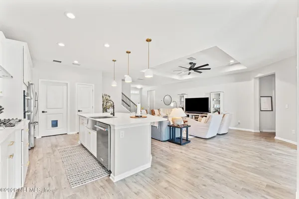 a living room with furniture a flat screen tv and kitchen view