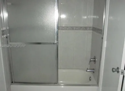 a bathroom with a glass shower door