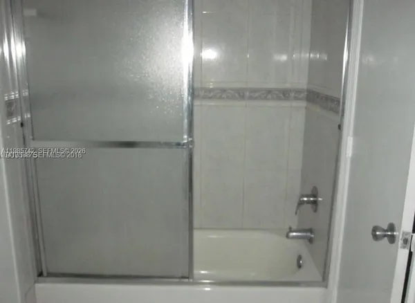 a bathroom with a glass shower door