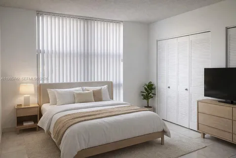 a bedroom with a bed and a flat tv screen on a dresser