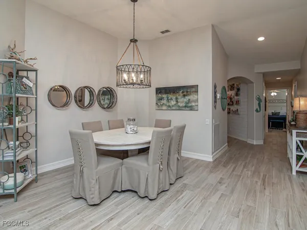 a dining room with furniture a chandelier and wooden floor