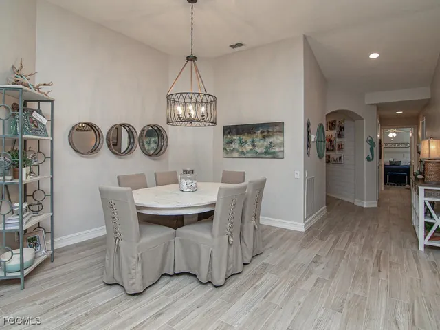 a dining room with furniture a chandelier and wooden floor