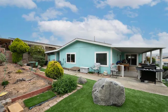 a view of a house with backyard and sitting area