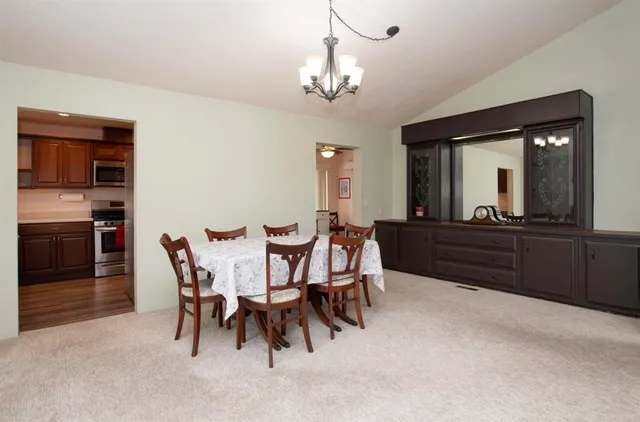 a view of a dining room with furniture and chandelier