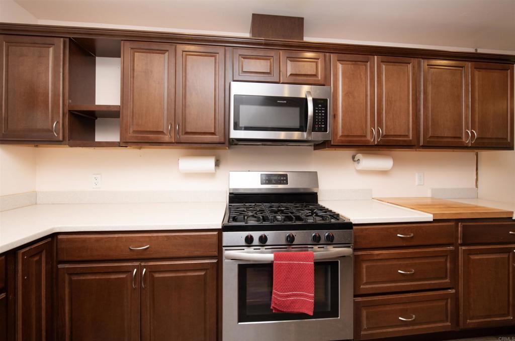 909 Richland Road, Unit 79 San Marcos, CA 92069 - Photo 4 of 17 a kitchen with wooden cabinets and a stove top oven