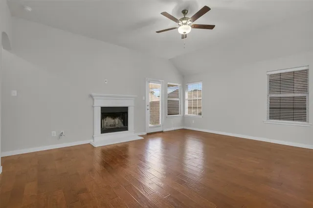 a view of an empty room with exposed radiator and fireplace