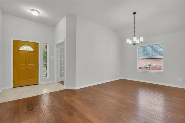 a view of a room with wooden floor and entryway