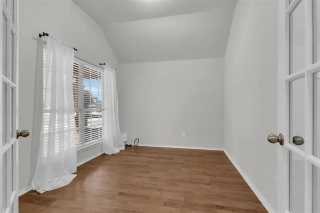a view of a room with wooden floor and windows