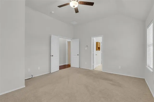 a view of a big room with ceiling fan and windows