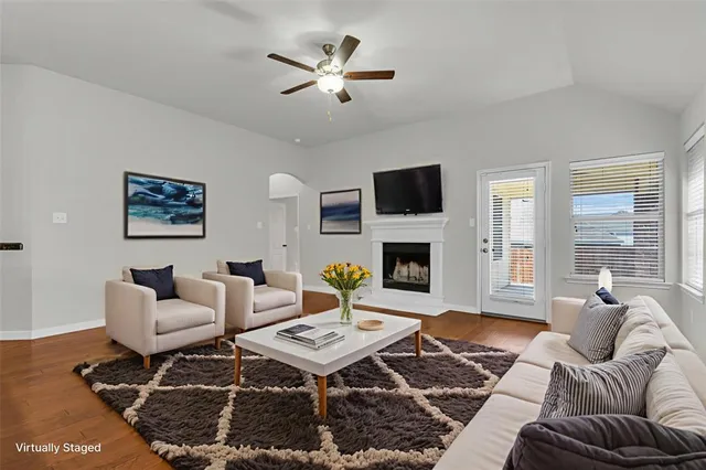 a living room with furniture a fireplace and a flat screen tv