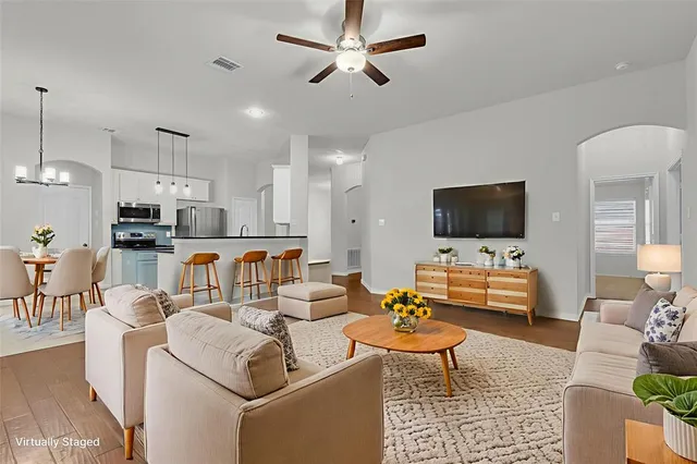 a living room with furniture kitchen view and a flat screen tv