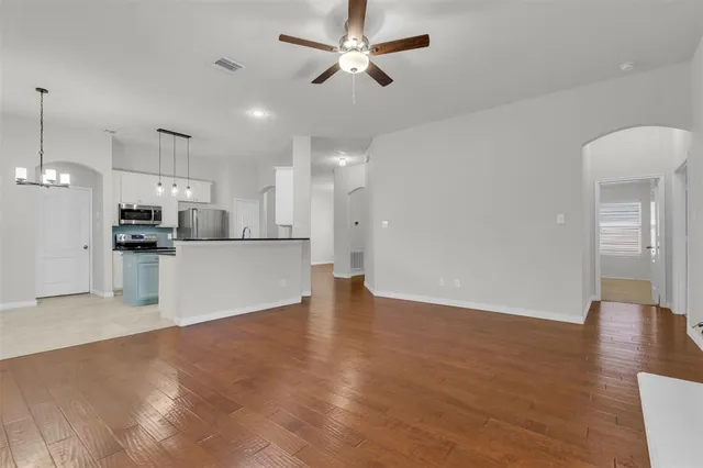 a view of kitchen with refrigerator stove and wooden floor
