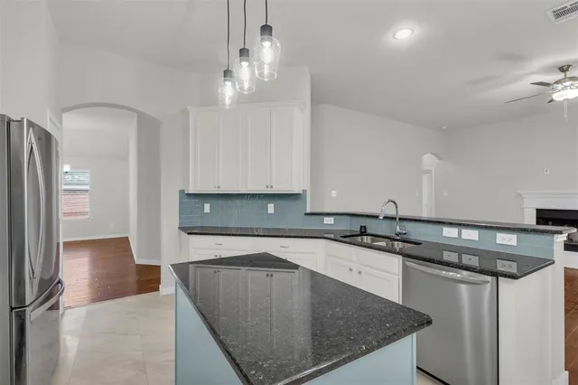 a kitchen with stainless steel appliances granite countertop a sink a refrigerator and a stove