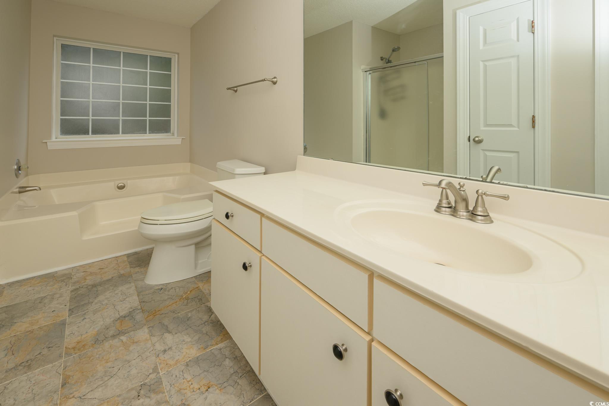 4283 Santolina Way, Unit D Murrells Inlet, SC 29576 - Photo 16 of 31 Full bathroom with vanity, a shower stall, and a garden tub