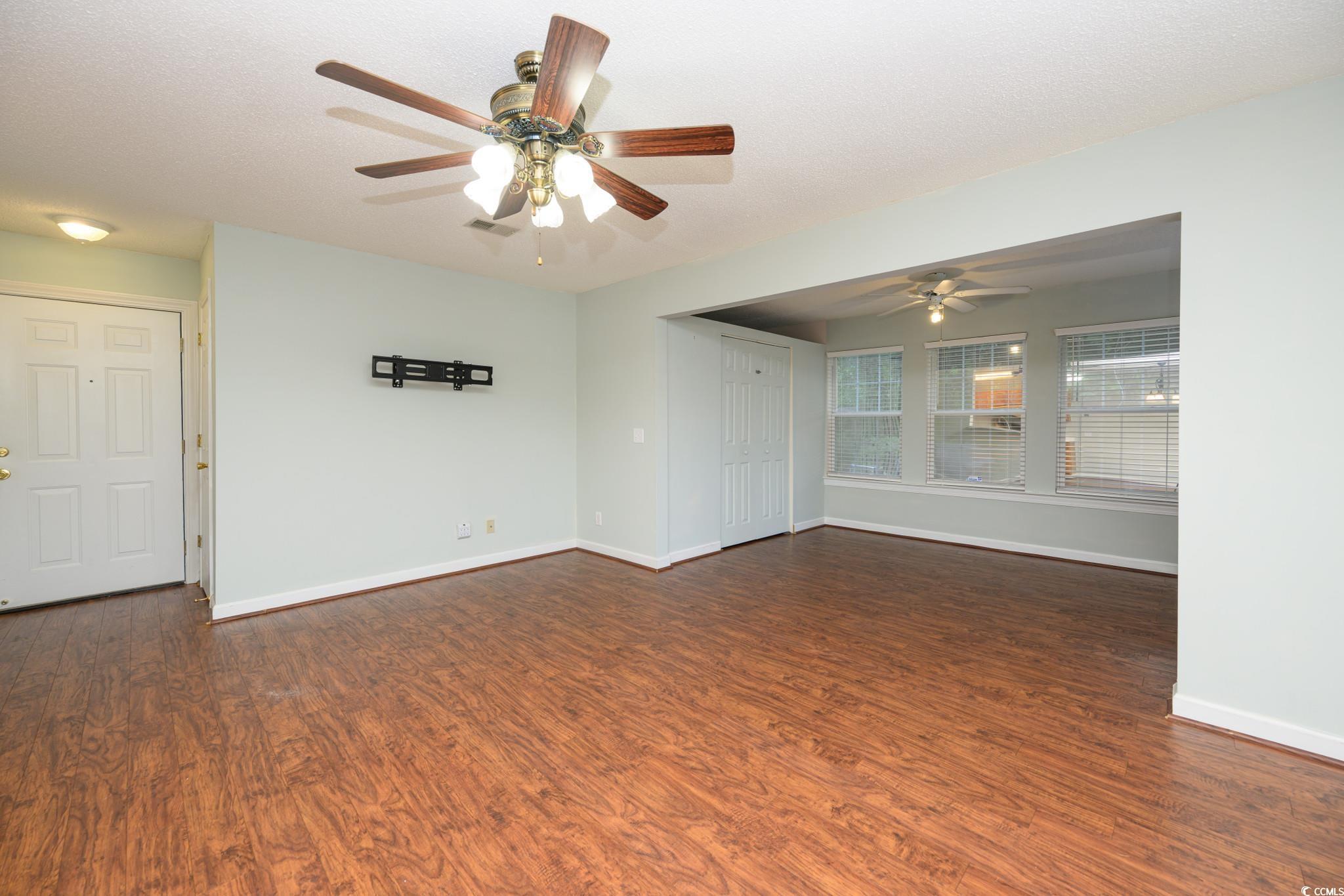 4283 Santolina Way, Unit D Murrells Inlet, SC 29576 - Photo 5 of 31 Spare room with dark wood-type flooring, a textured ceiling, and a ceiling fan
