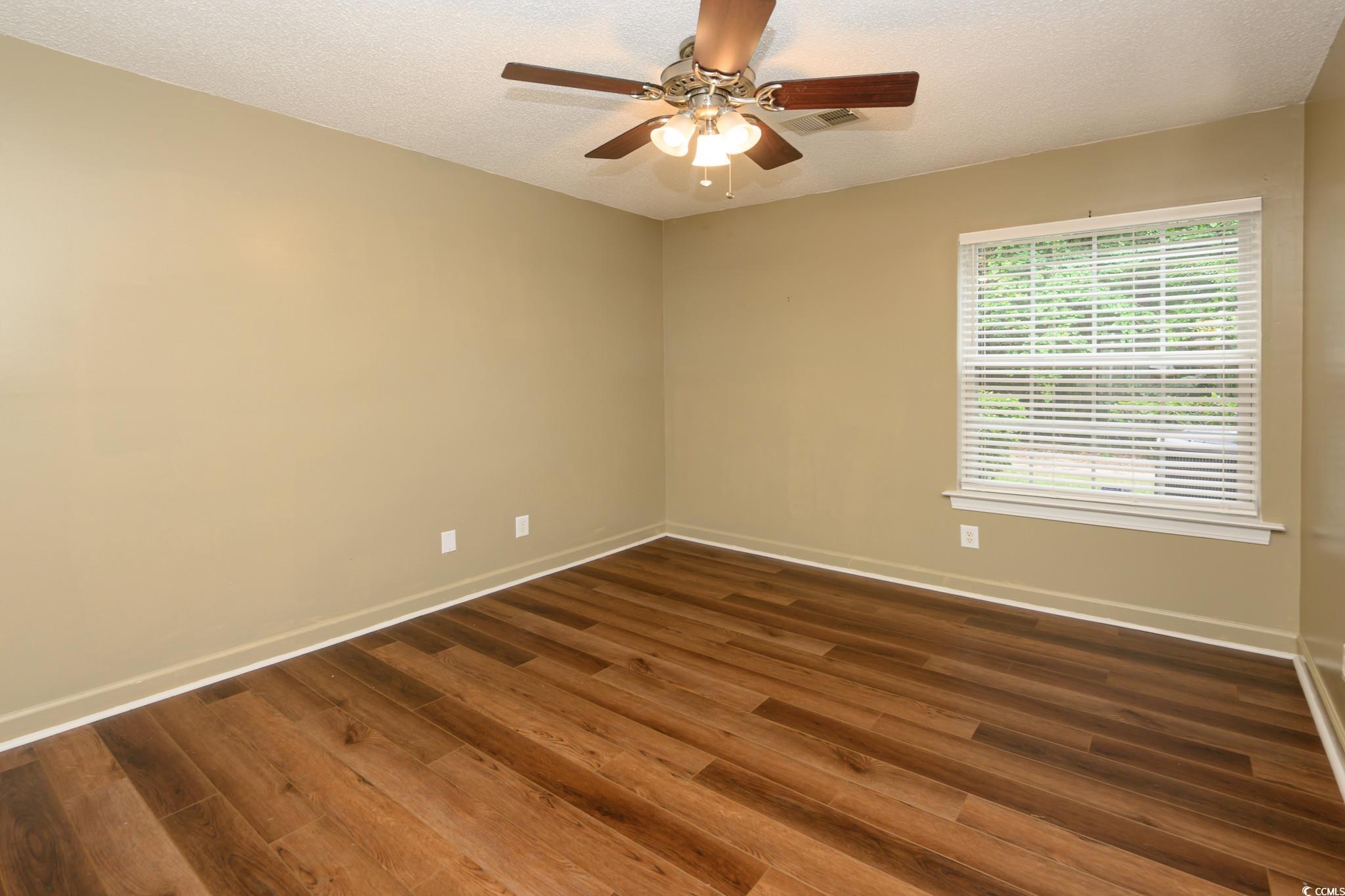 4283 Santolina Way, Unit D Murrells Inlet, SC 29576 - Photo 9 of 31 Empty room with a textured ceiling, dark wood-type flooring, and ceiling fan