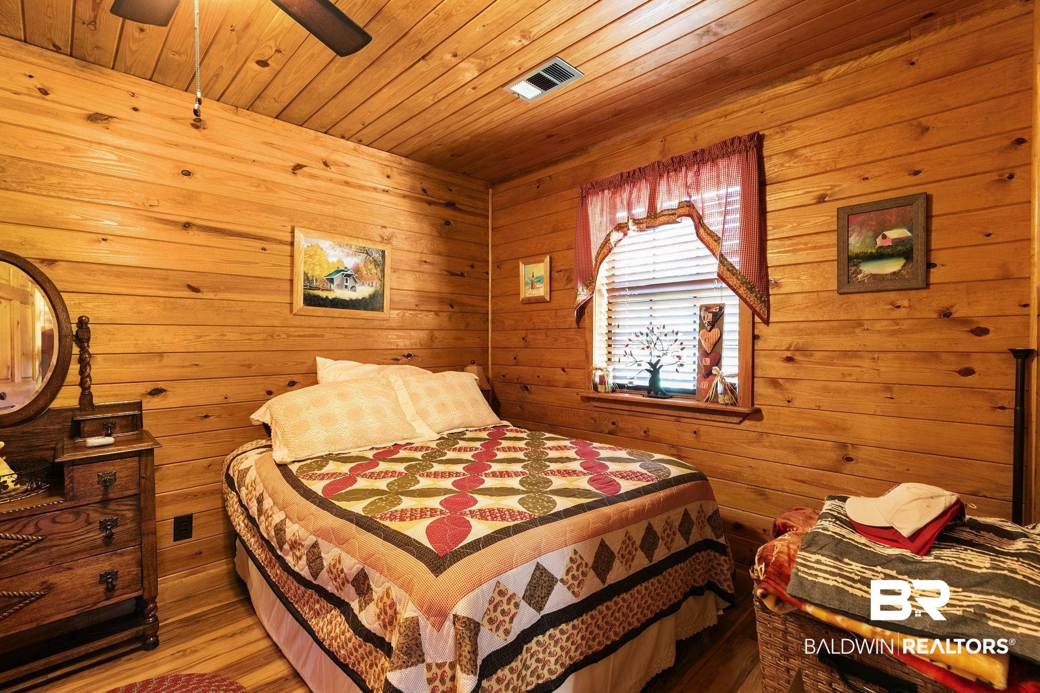 724 Rowell Lane Brewton, AL 36426 - Photo 22 of 40 Bedroom featuring wood walls, wooden ceiling, wood finished floors, and a ceiling fan