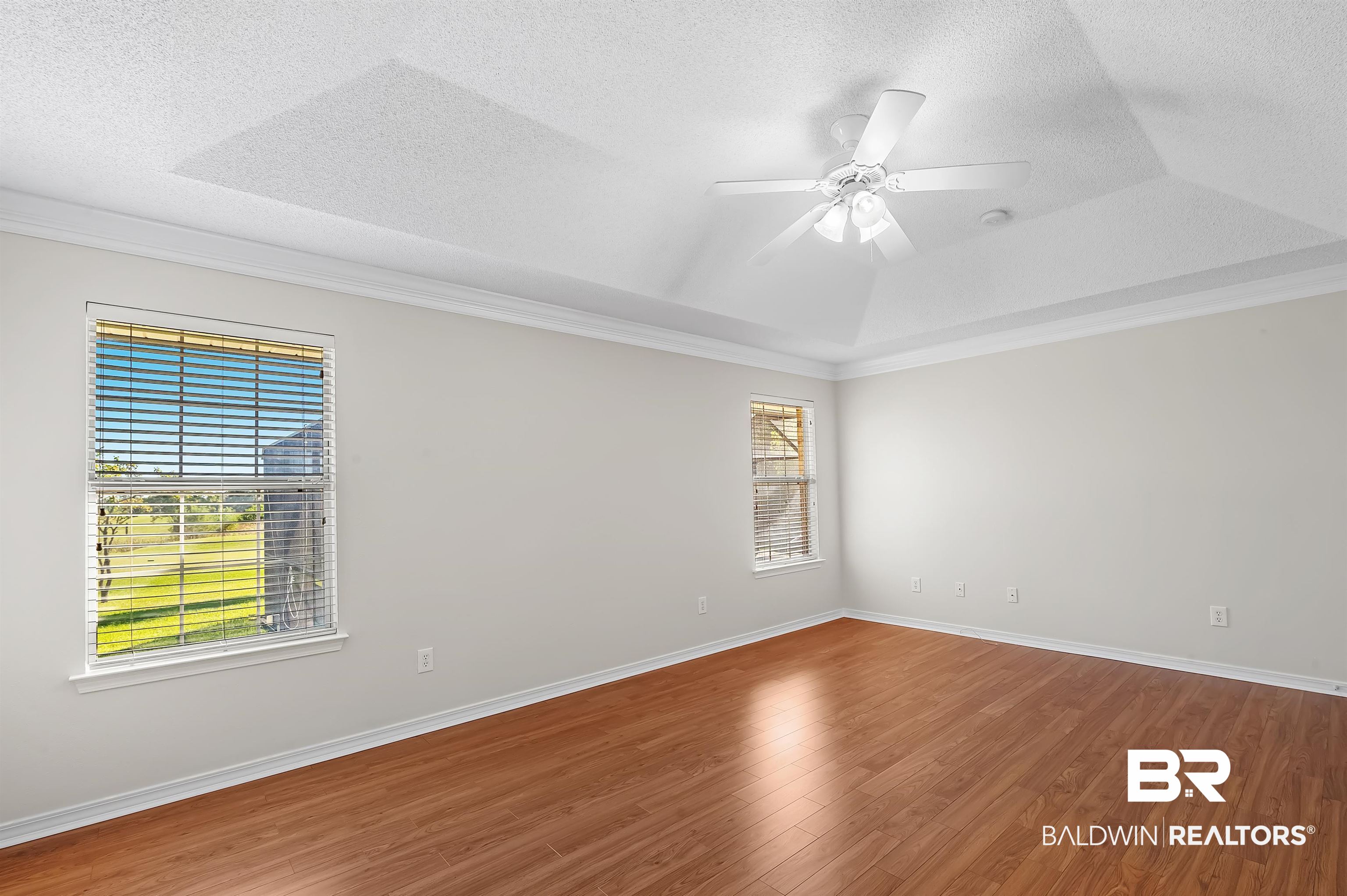 421 Collinwood Loop Foley, AL 36535 - Photo 36 of 62 Spare room with a textured ceiling, hardwood / wood-style flooring, a raised ceiling, and ceiling fan