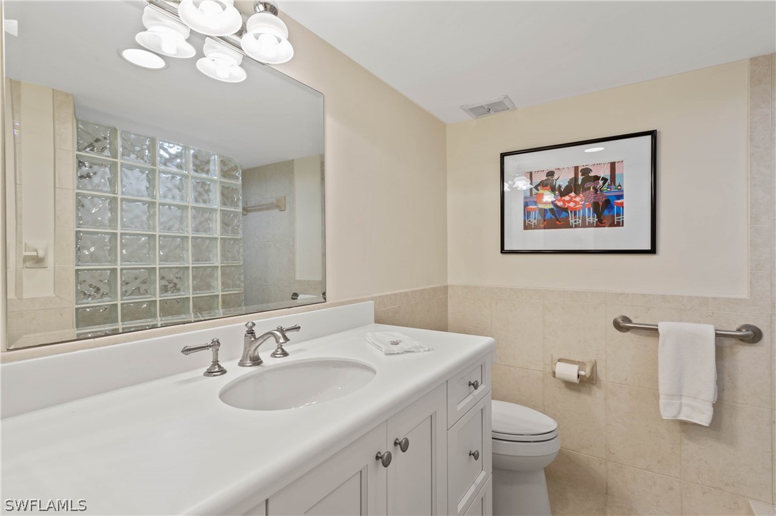 975 Sand Castle Road Sanibel, FL 33957 - Photo 18 of 24 a bathroom with a sink a toilet and a large mirror