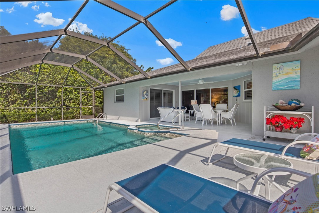 975 Sand Castle Road Sanibel, FL 33957 - Photo 21 of 24 a view of a patio with table and chairs potted plants and floor to ceiling window