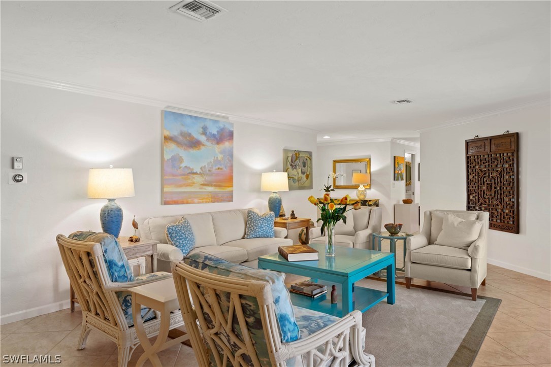 975 Sand Castle Road Sanibel, FL 33957 - Photo 5 of 24 a living room with furniture a dining table and a piano table with wooden floor