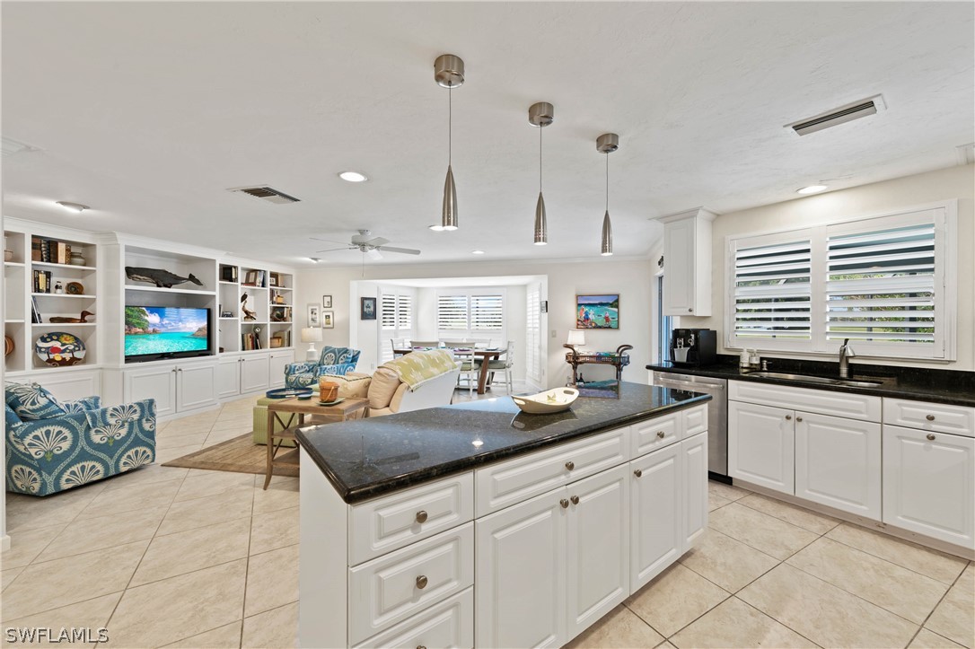 975 Sand Castle Road Sanibel, FL 33957 - Photo 8 of 24 a kitchen with granite countertop a sink and white cabinets