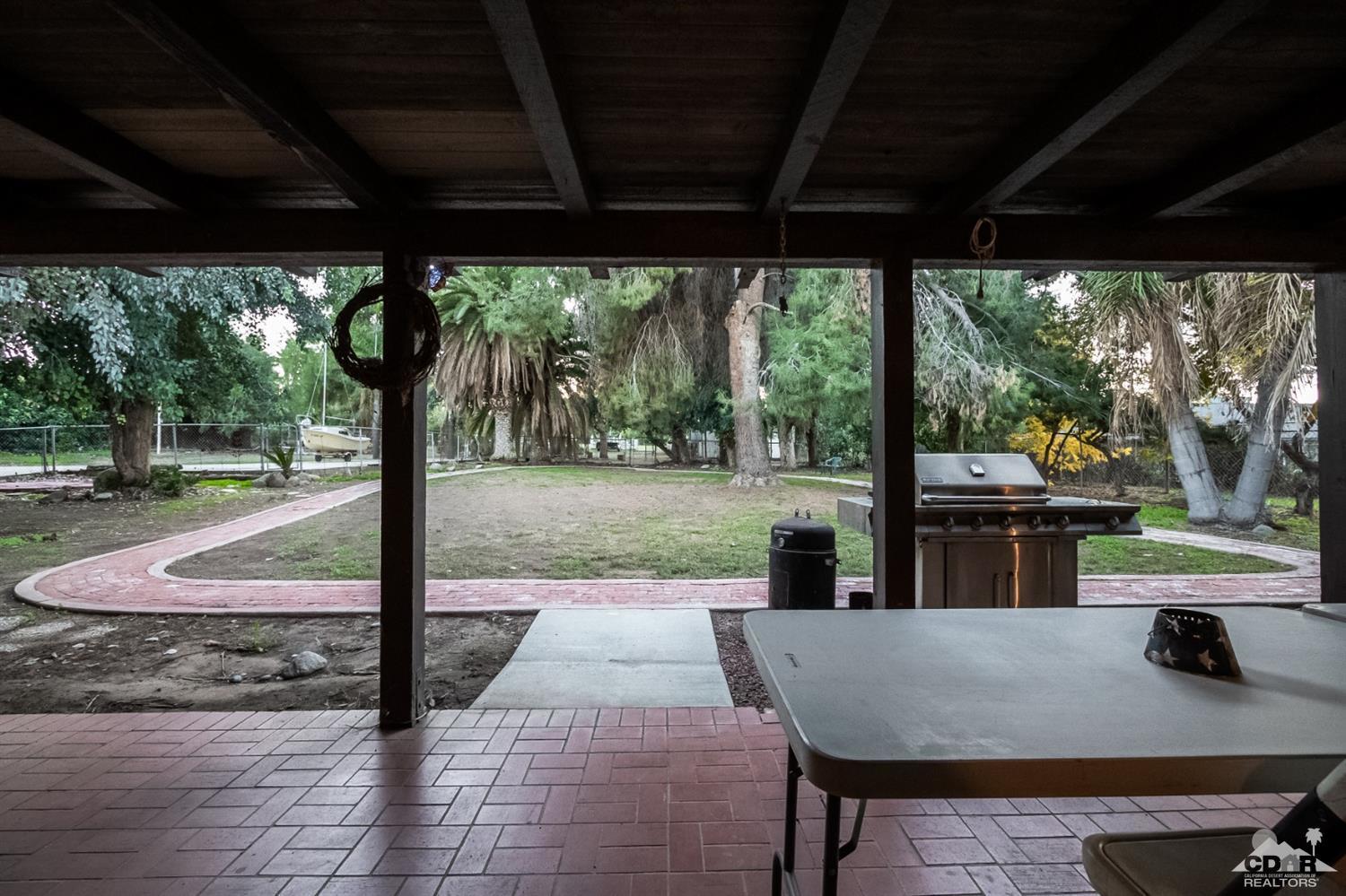 2132 John Street Riverside, CA 92503 - Photo 25 of 52 a view of a patio with table and chairs potted plants with wooden floor and fence