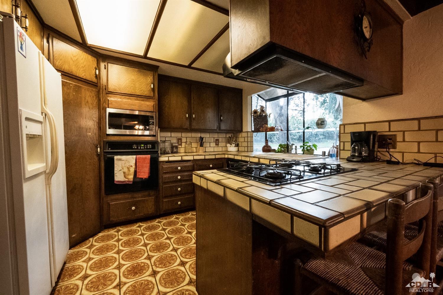 2132 John Street Riverside, CA 92503 - Photo 30 of 52 a kitchen with stainless steel appliances granite countertop a stove top oven a sink and a microwave