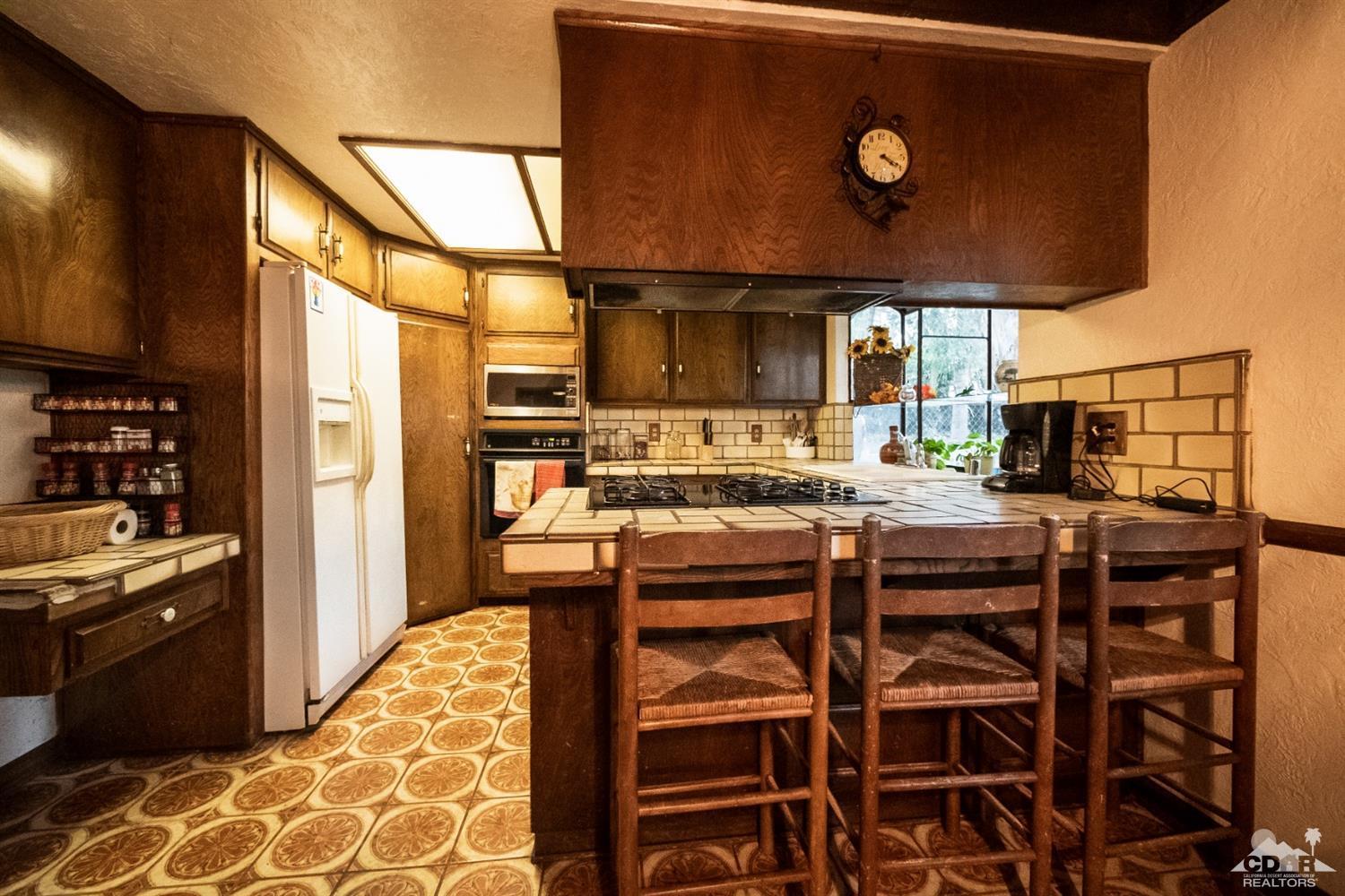 2132 John Street Riverside, CA 92503 - Photo 31 of 52 a kitchen with stainless steel appliances granite countertop a stove and a refrigerator