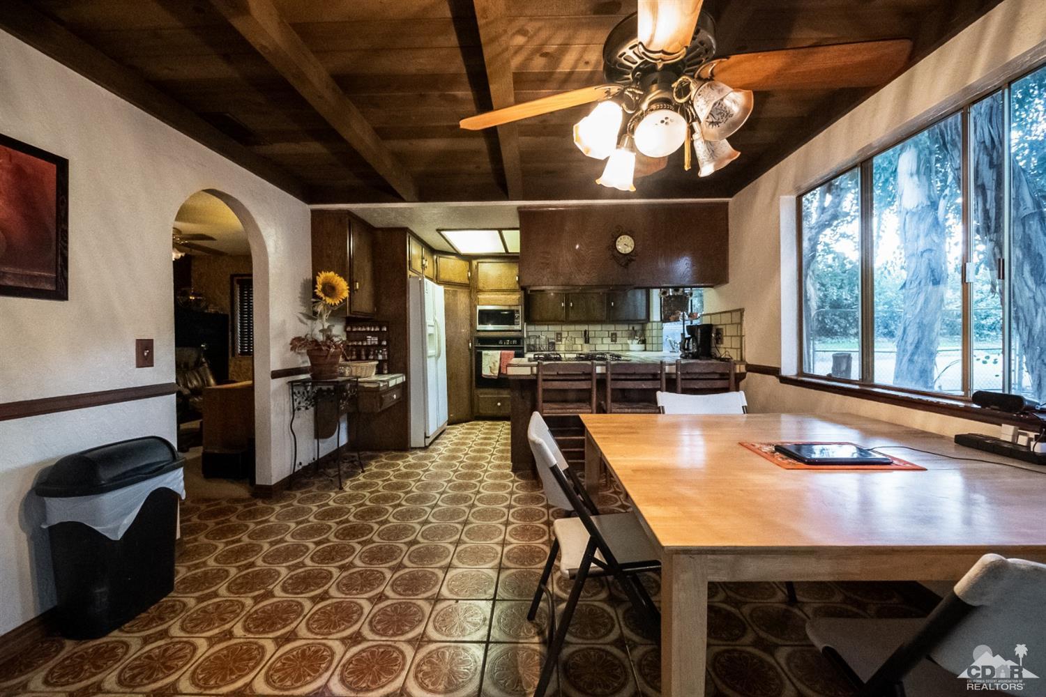 2132 John Street Riverside, CA 92503 - Photo 34 of 52 a kitchen with stainless steel appliances granite countertop a stove a refrigerator a sink a dining table and chairs with wooden floor
